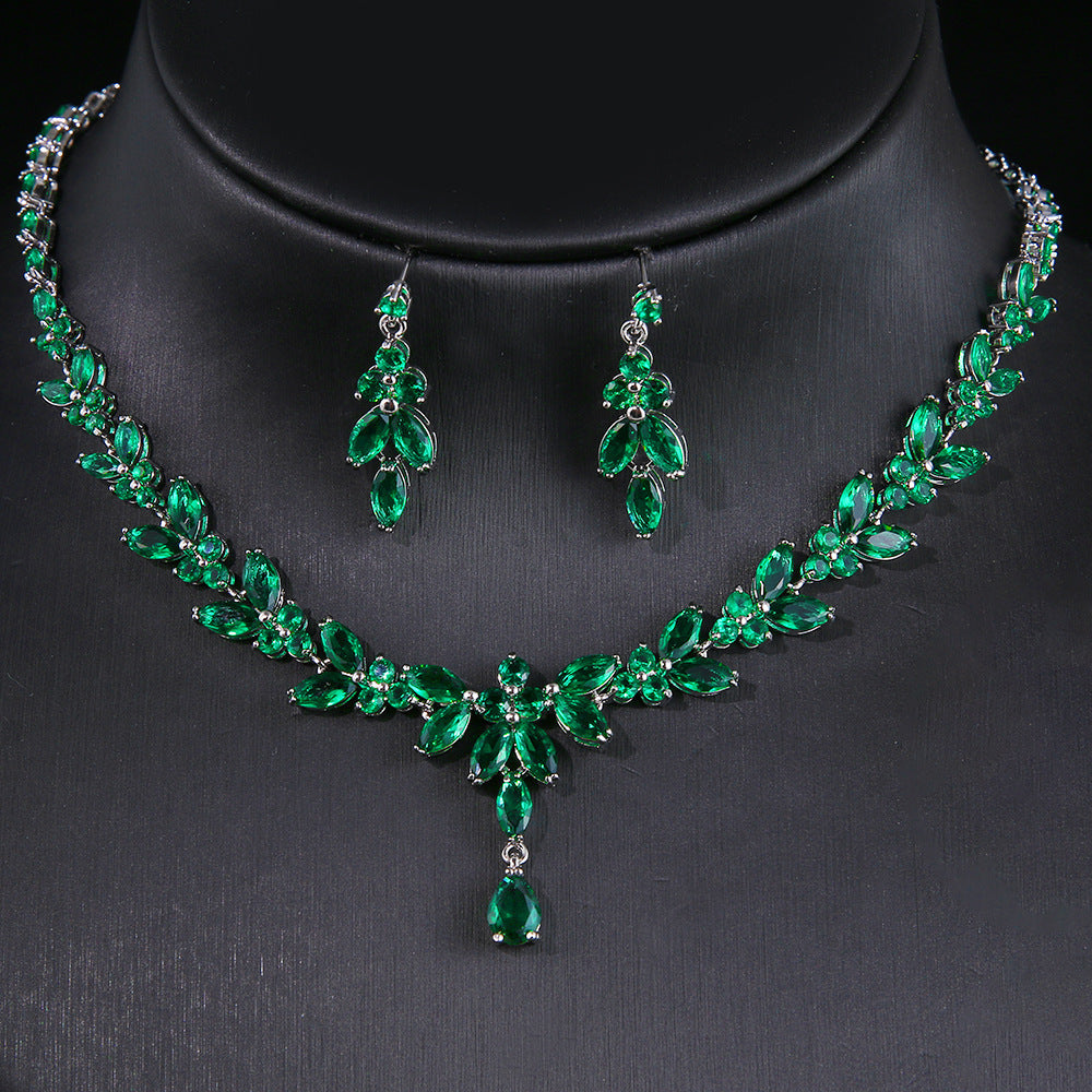 Green gemstone necklace and earrings on a black background