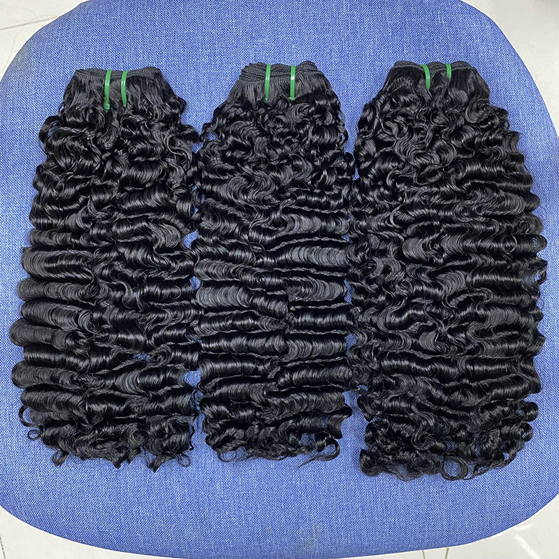 Three bundles of curly hair extensions on a blue surface