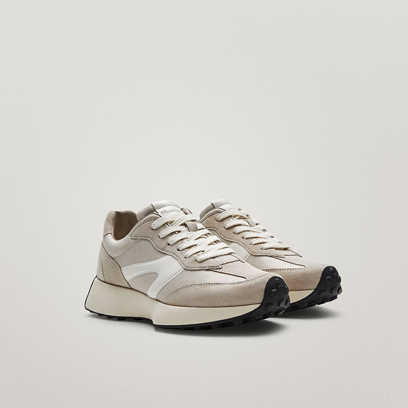 Pair of beige sneakers on a light gray background