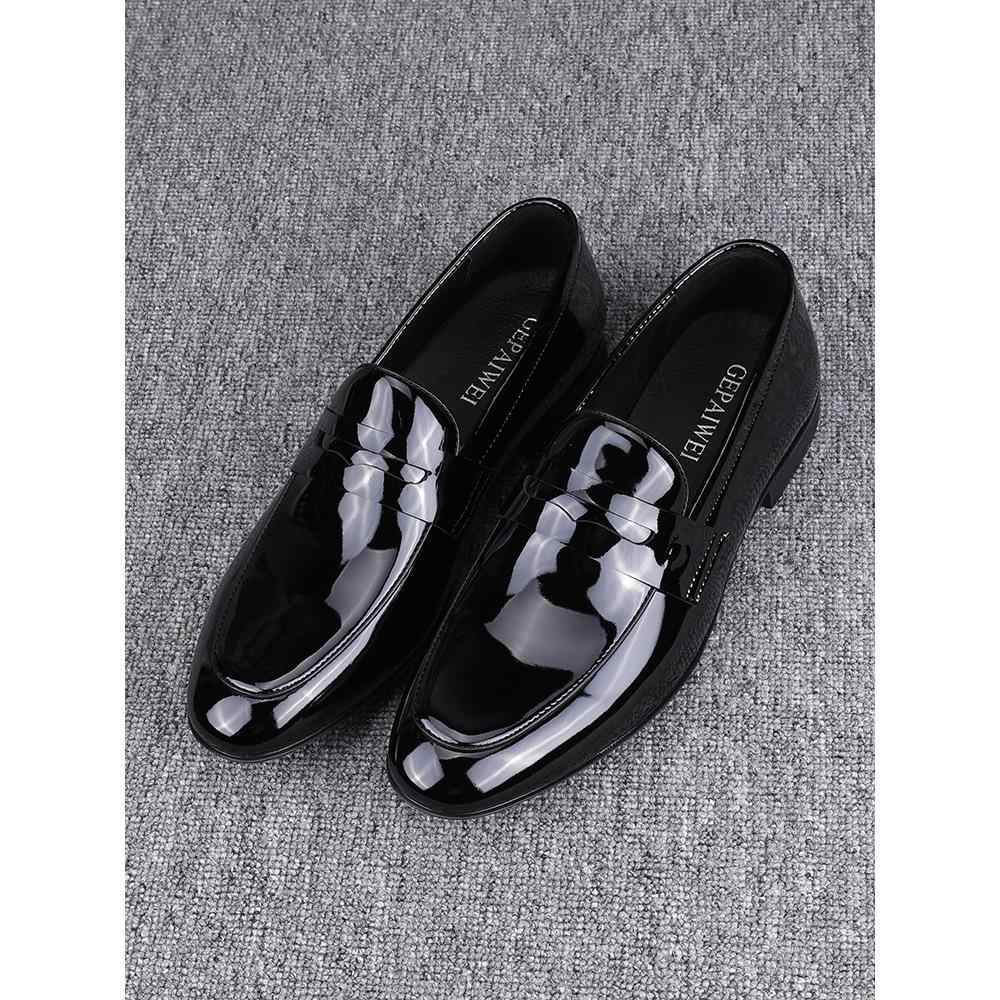 Black glossy loafers on a textured gray surface