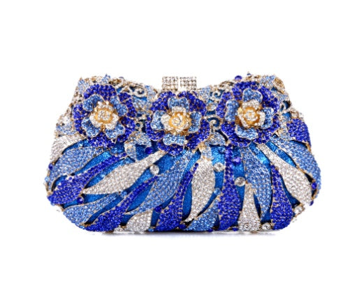 Decorative clutch with blue floral design and sparkling stones on a white background