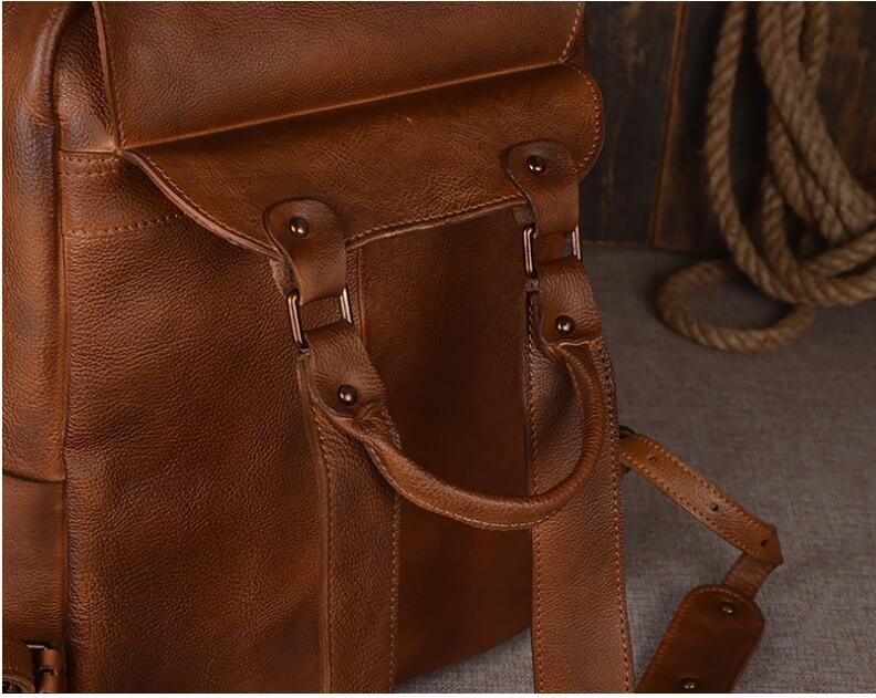 Close-up of a brown leather backpack with visible stitching and hardware.
