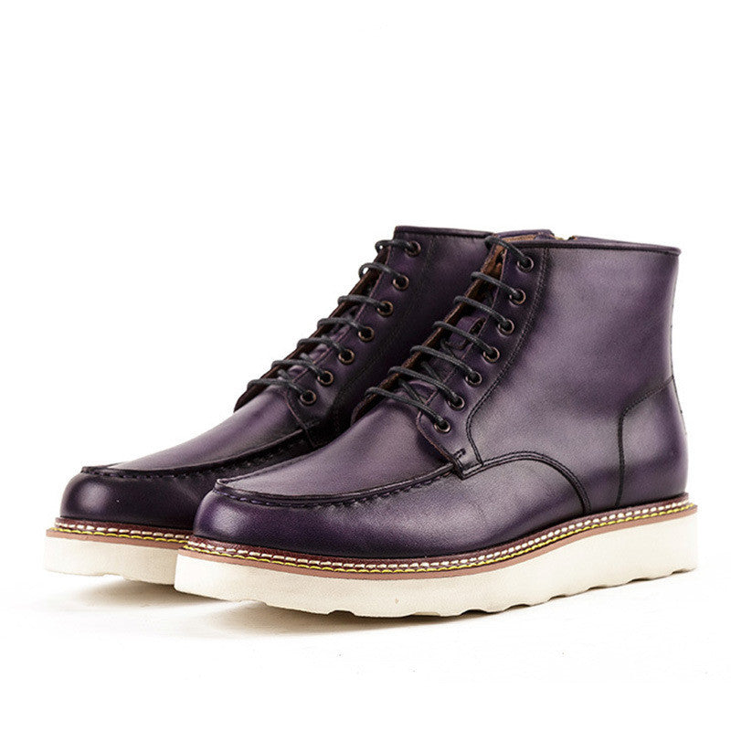 Pair of purple leather boots with white soles on a white background