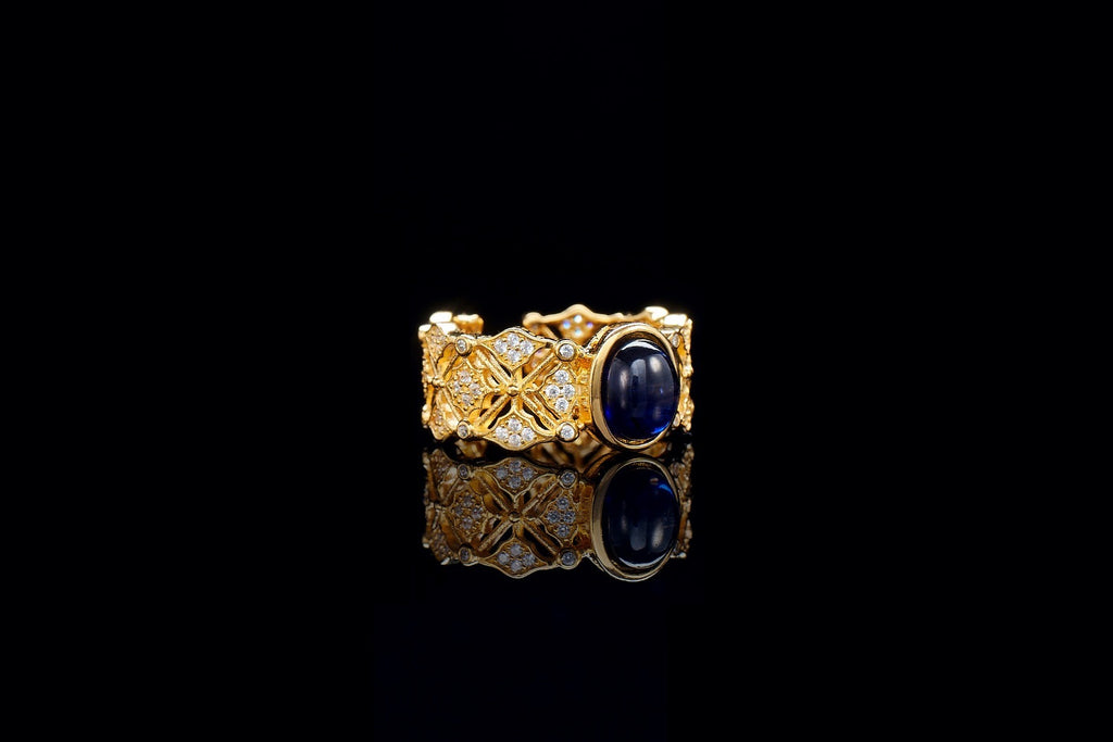 Gold ring with a blue gemstone on a black background