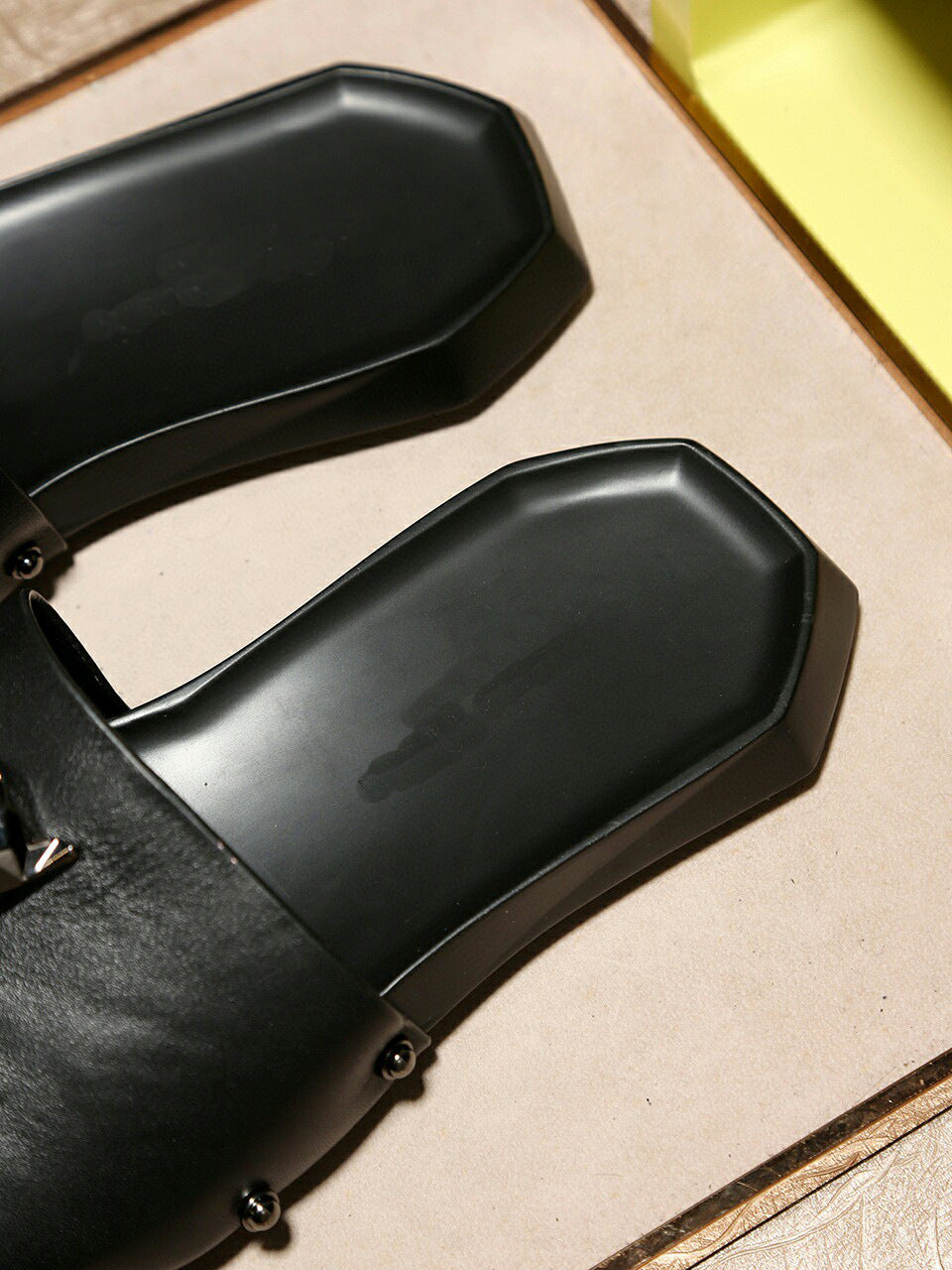 Black motorcycle seat covers on a wooden surface