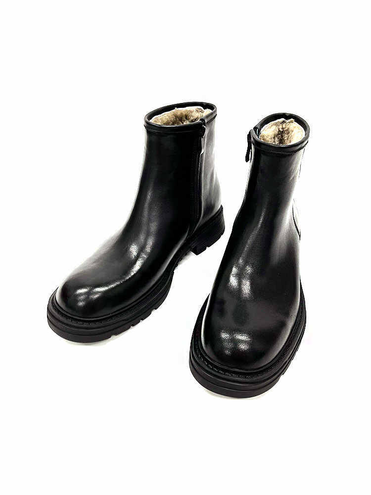Pair of black leather boots with fur lining on a white background