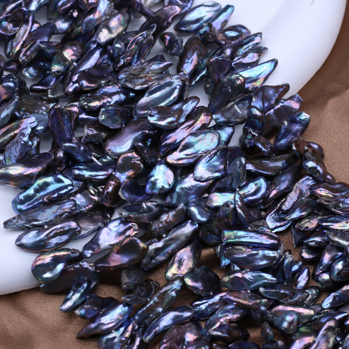 Iridescent dark blue pearls on a white surface