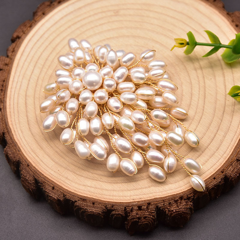 Pearl brooch on a wooden surface with a natural background
