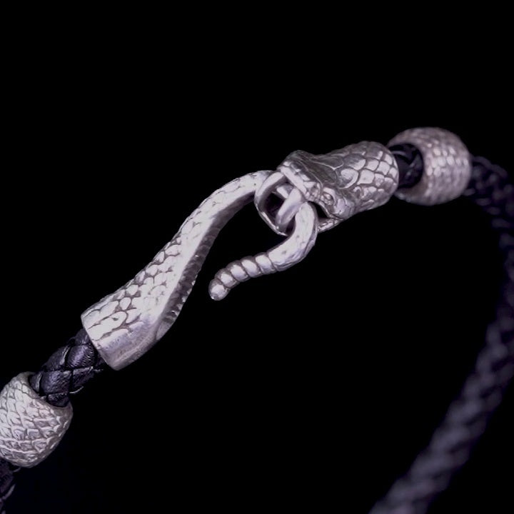 Bracelet with silver snake head clasp on a black background