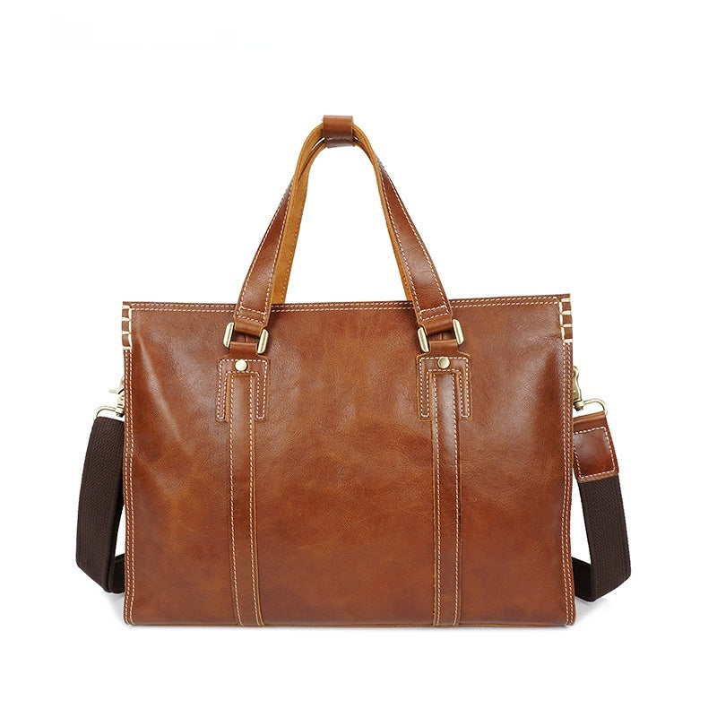 Brown leather briefcase with shoulder strap on a white background