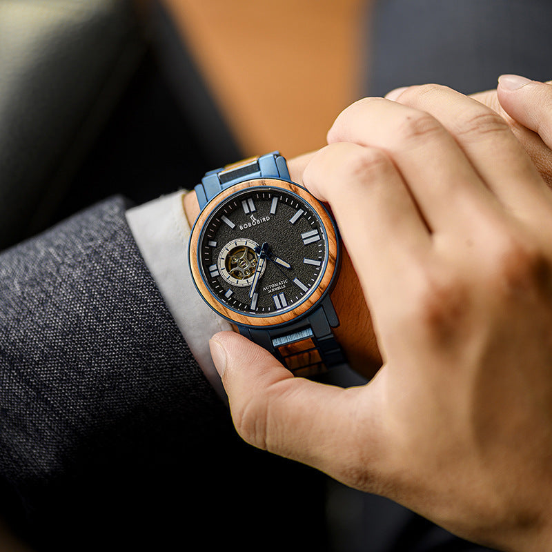 Person wearing a detailed wristwatch with a focus on the watch face.