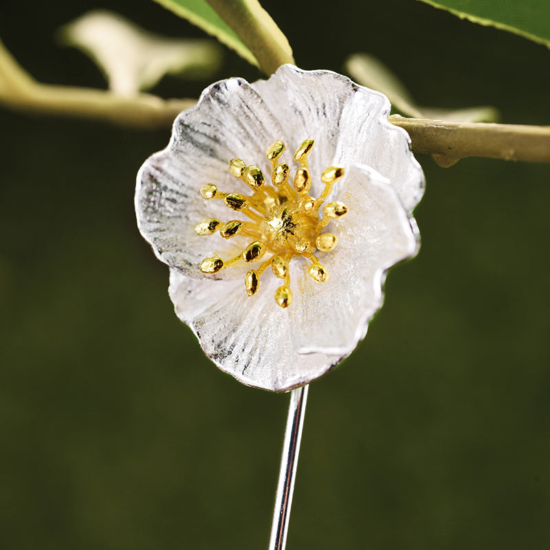 Close-up of a white flower with gold center on a blurred green background