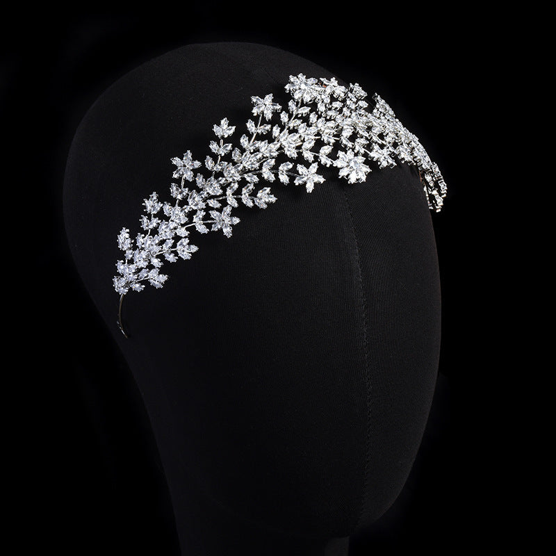 Silver floral headband on a black mannequin head against a black background
