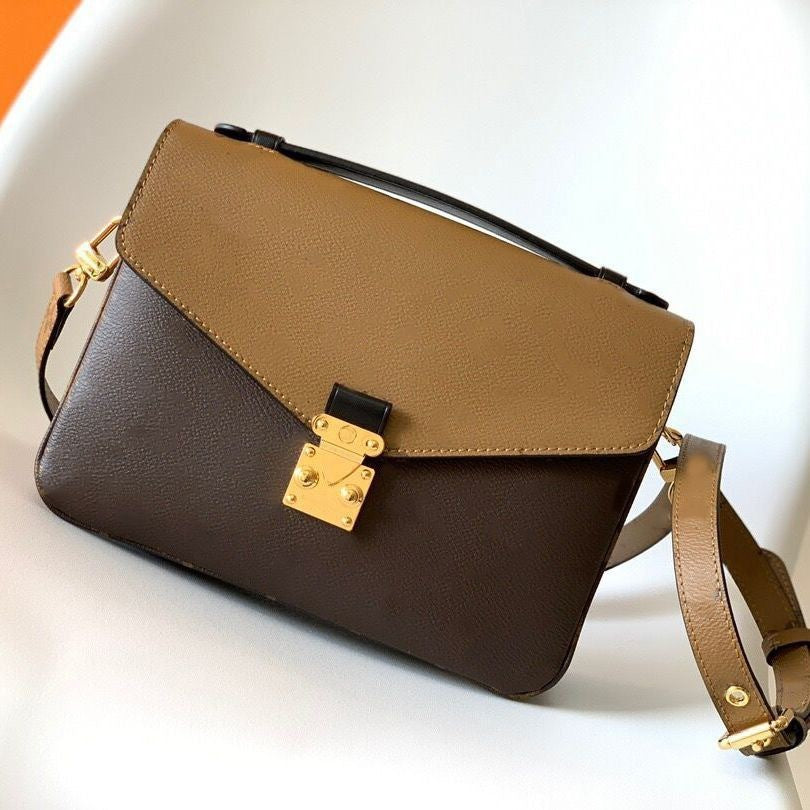 Brown and beige handbag with a gold clasp on a white background