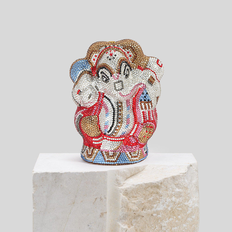 Decorative figurine of a monkey with colorful patterns on a white pedestal against a light gray background