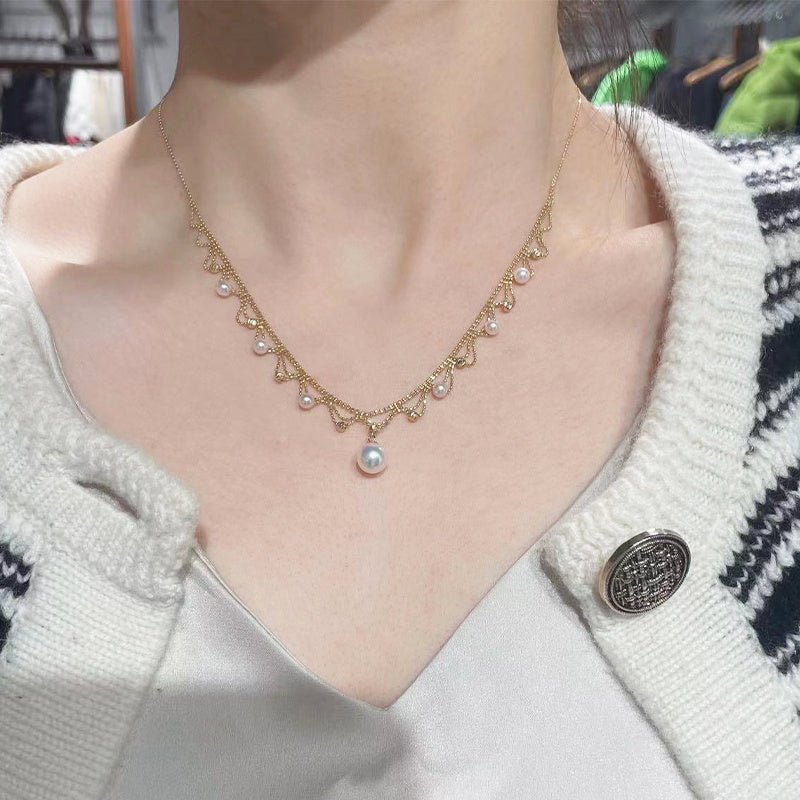 Pearl necklace worn by a person with a white cardigan