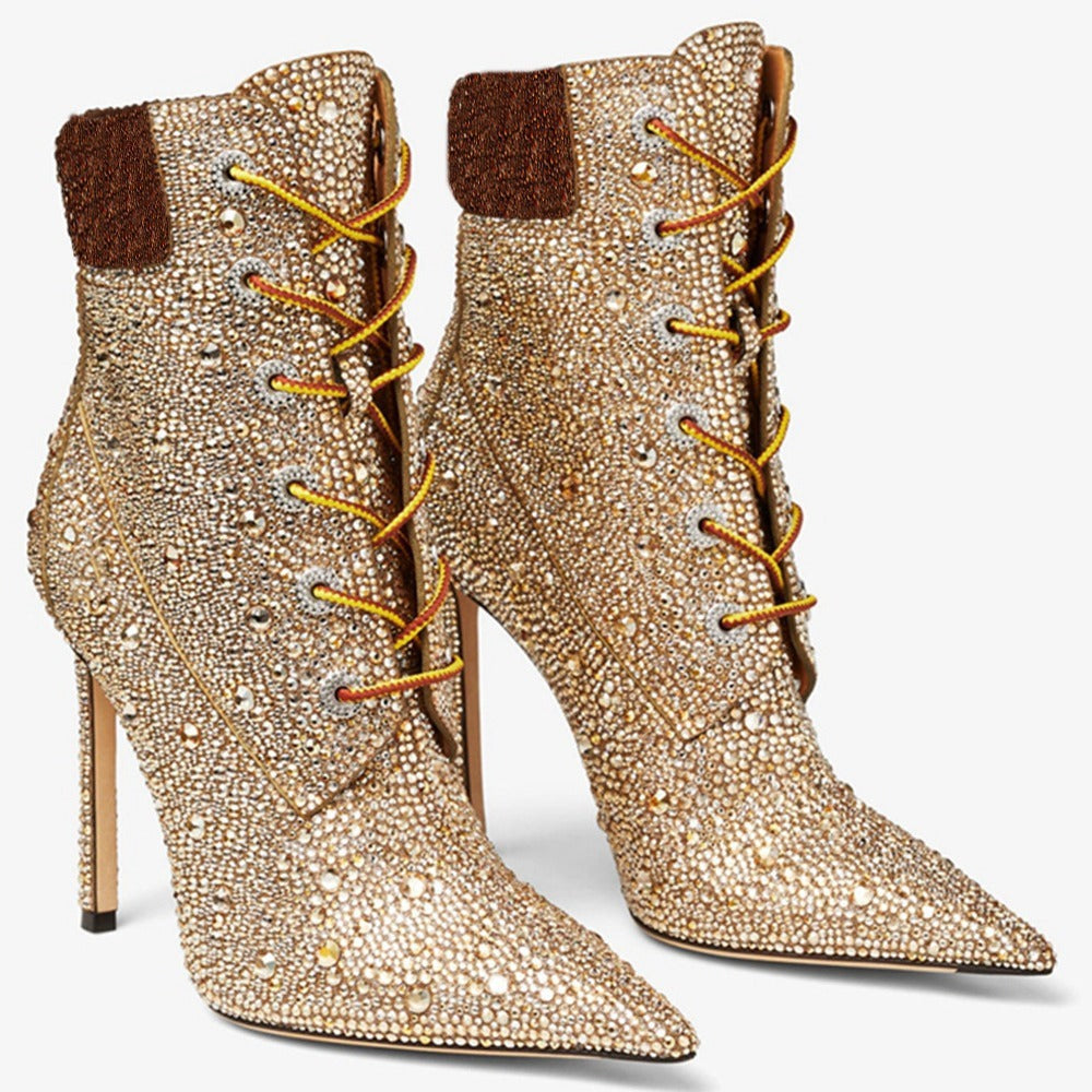 Gold embellished high-heeled boots with brown accents on a white background