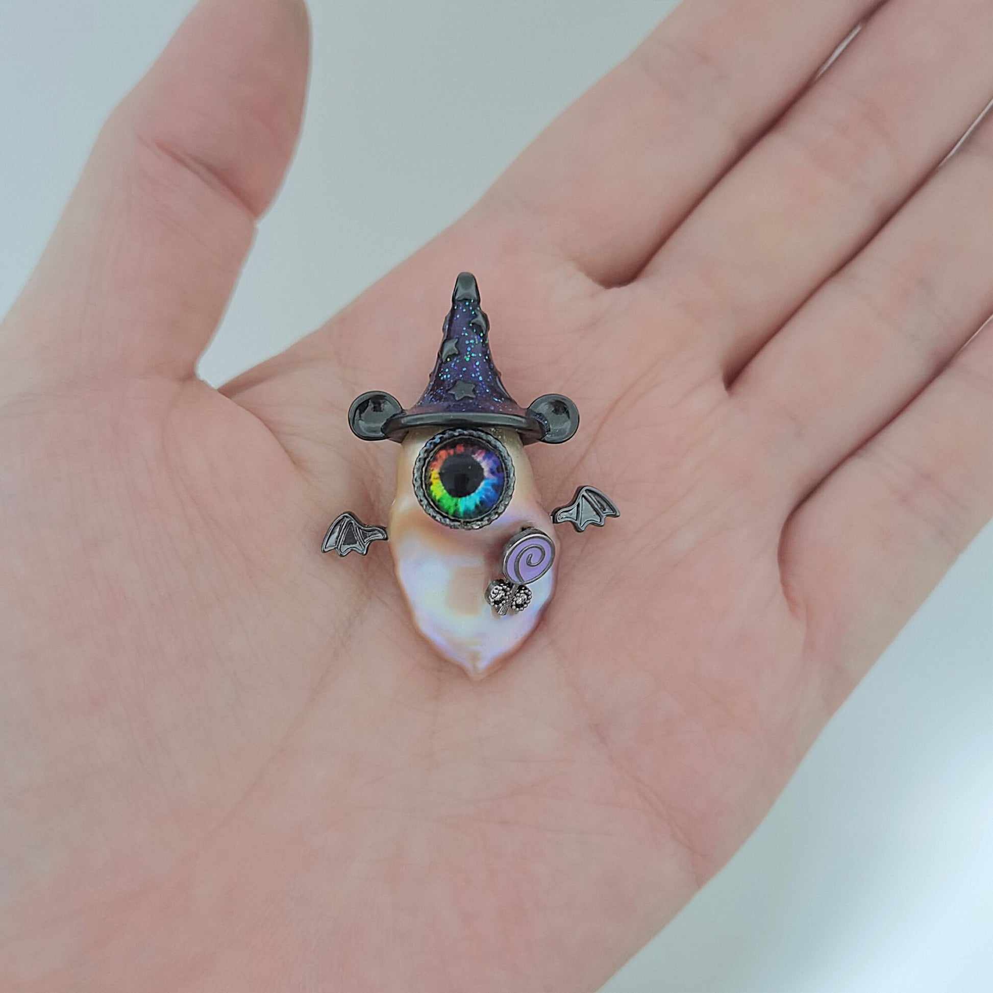 Hand holding a unique necklace with a colorful pendant