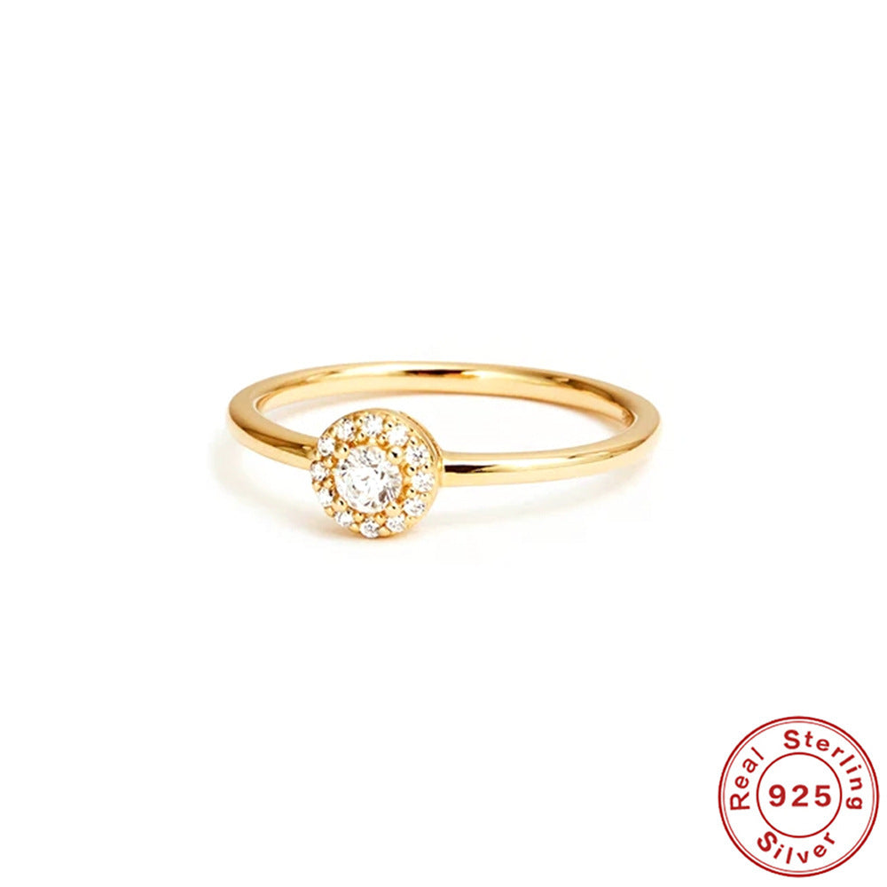 Gold ring with a diamond on a white background, featuring 'Real Sterling 925' stamp.