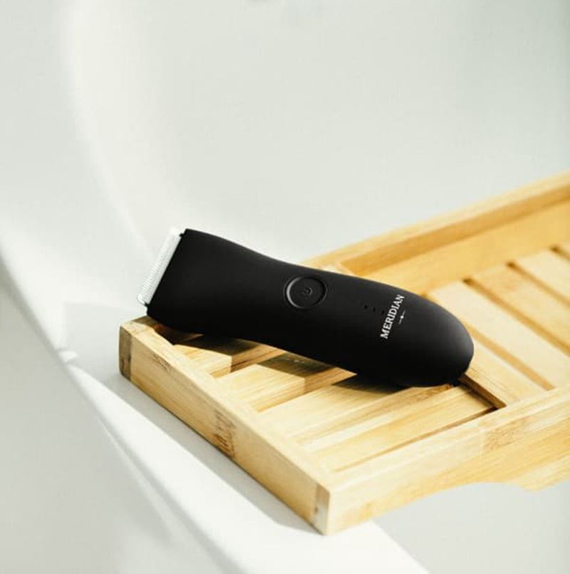 Black grooming tool on a wooden surface with a white background