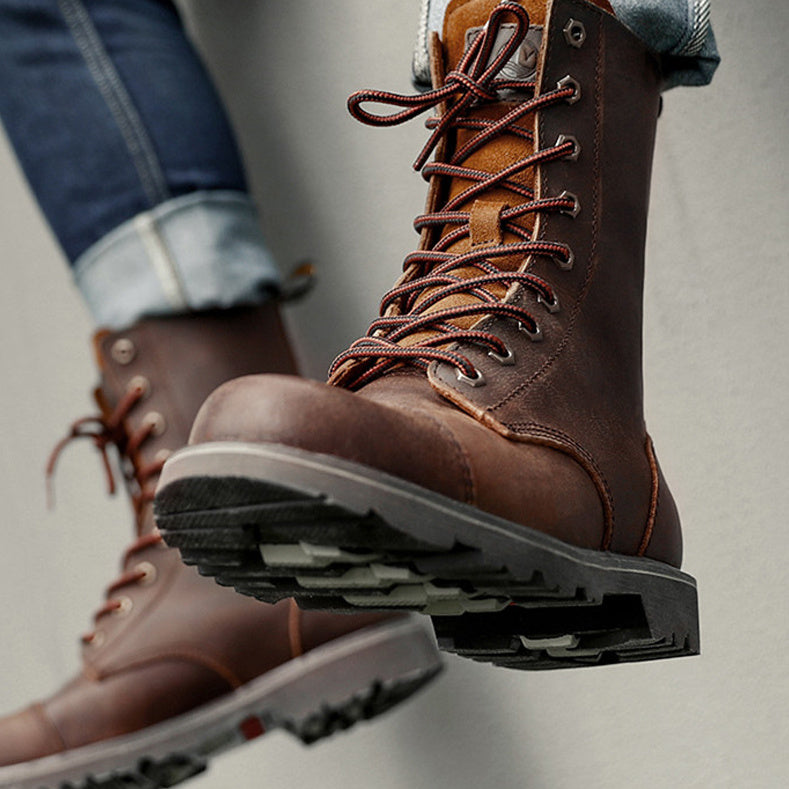 Brown leather boots with laces on a neutral background