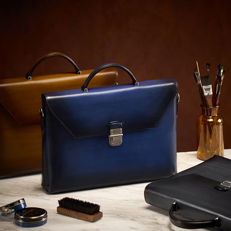 Blue leather briefcase on a wooden surface with other bags and grooming items.
