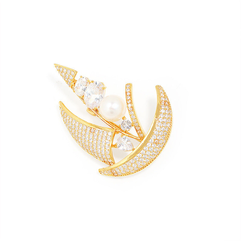 Gold and pearl brooch on a white background