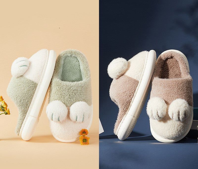Pair of plush slippers with paw-like toes on a beige and blue background
