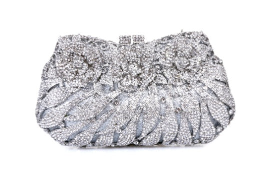 Silver clutch bag with intricate detailing on a white background