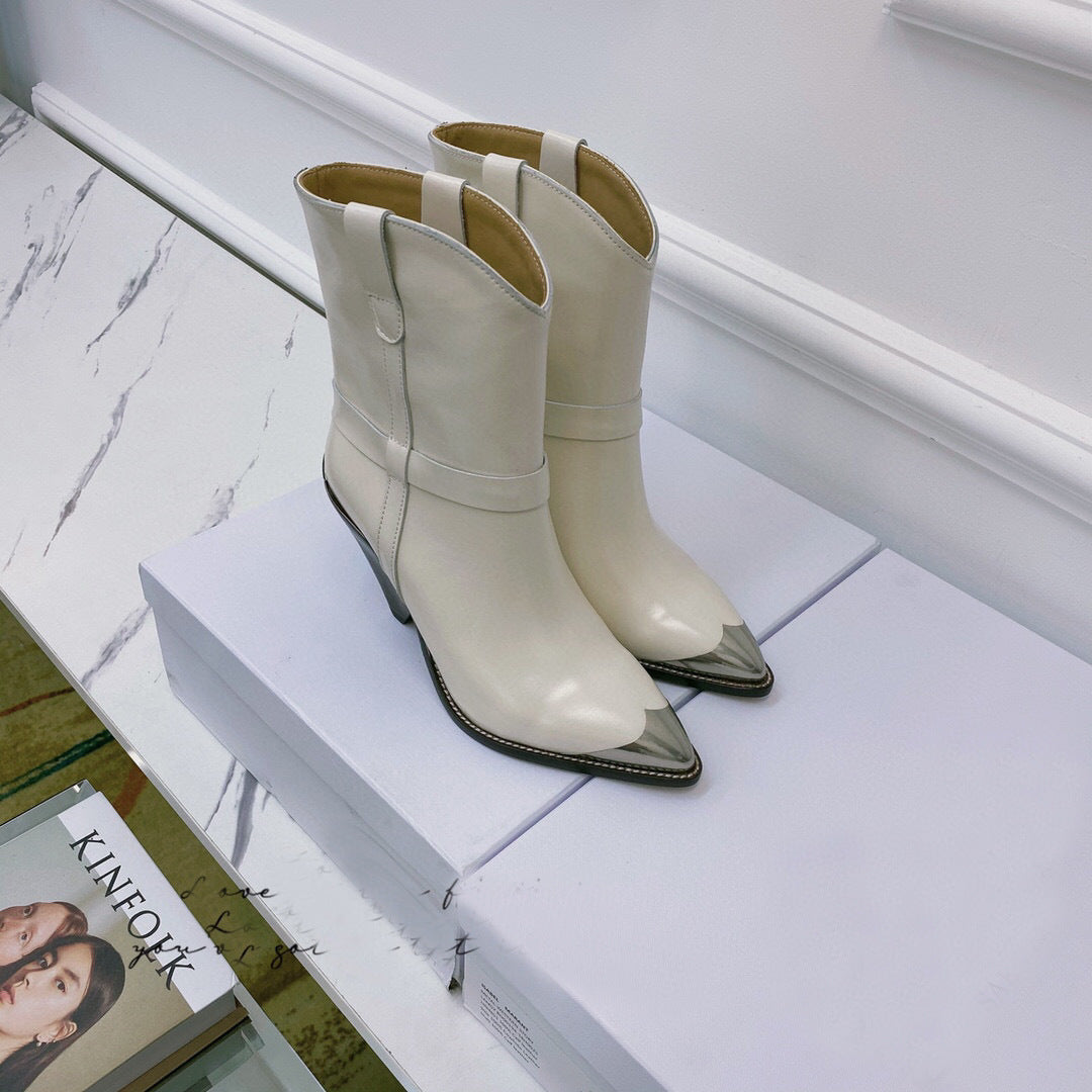 Pair of white cowboy boots with metallic tips on a white surface.
