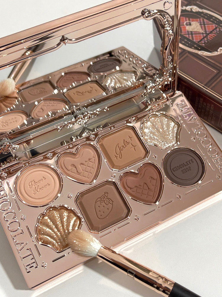 Makeup palette with heart-shaped compartments and a brush on a light background