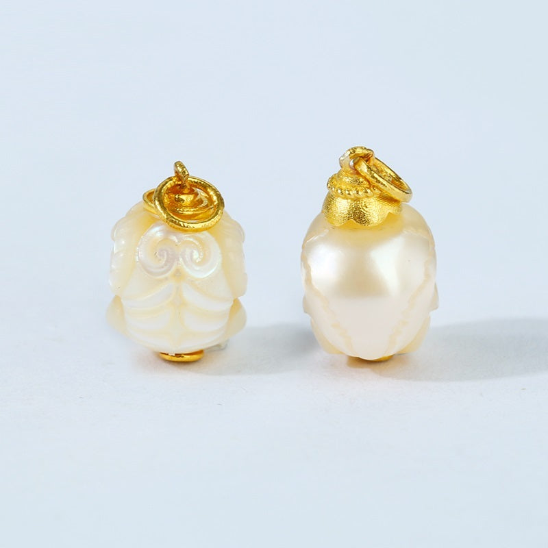 Pair of pearl earrings with gold tops on a light gray background