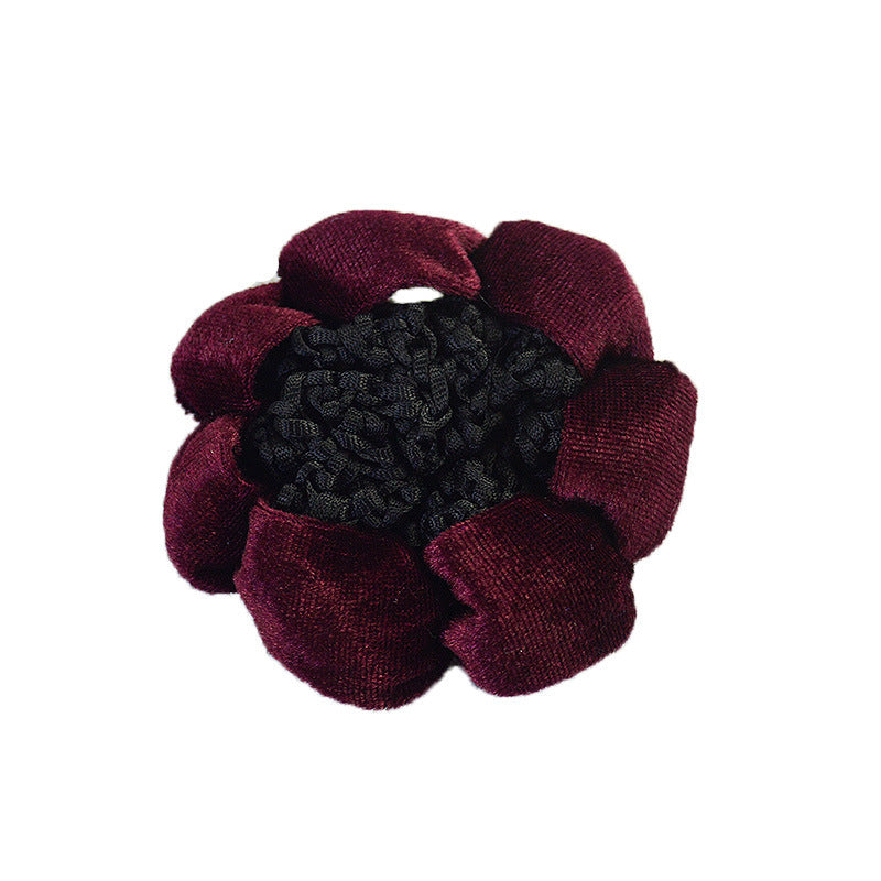 Maroon flower-shaped hair clip with black center on a white background