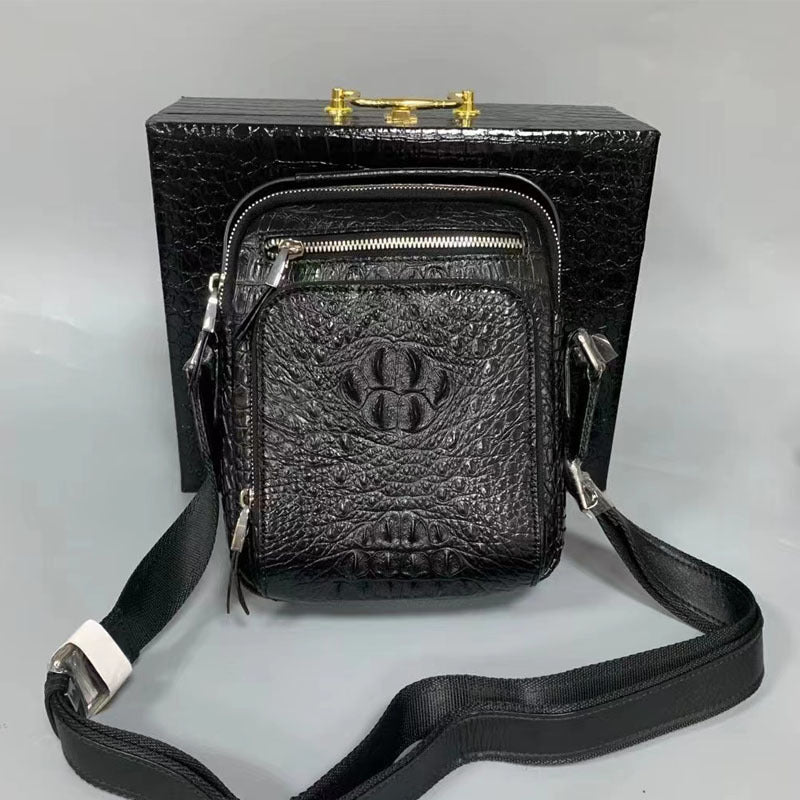 Black textured crossbody bag with a strap on a gray background