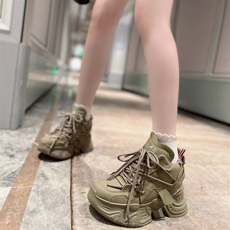 Green sneakers worn indoors on a person's feet.