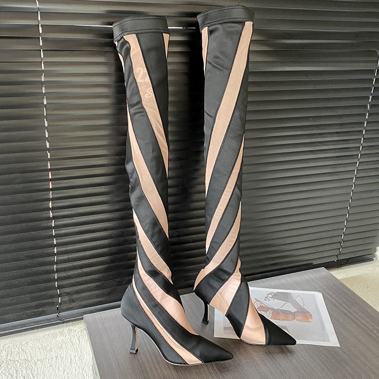 Black and beige striped knee-high boots on a wooden floor with blinds in the background