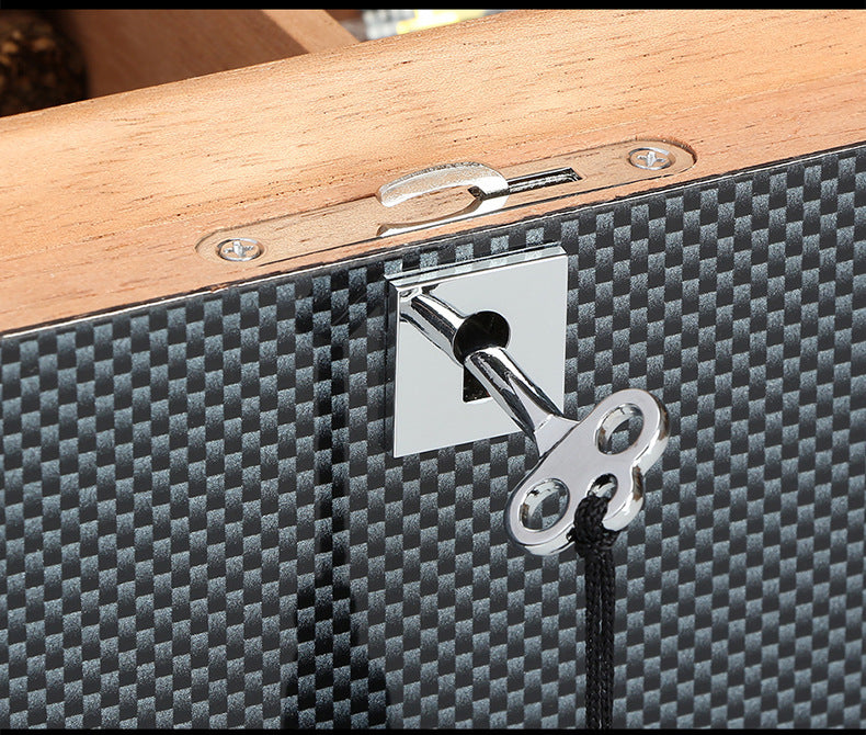 Close-up of a lock mechanism on a carbon fiber case with wooden top.
