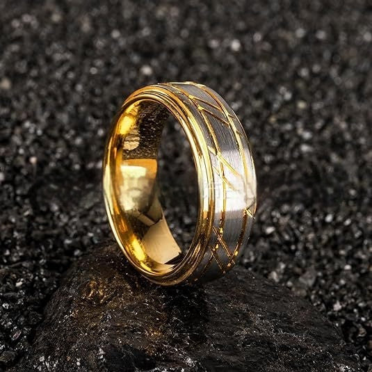 Gold ring with a textured design on a dark, textured surface