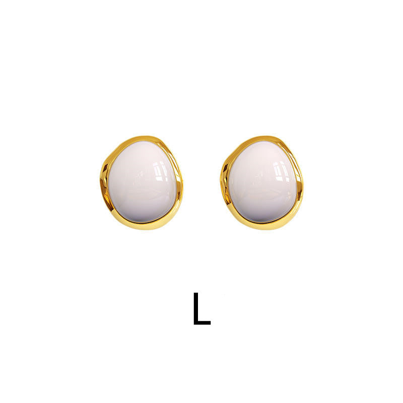 Pair of gold earrings with white stones on a white background