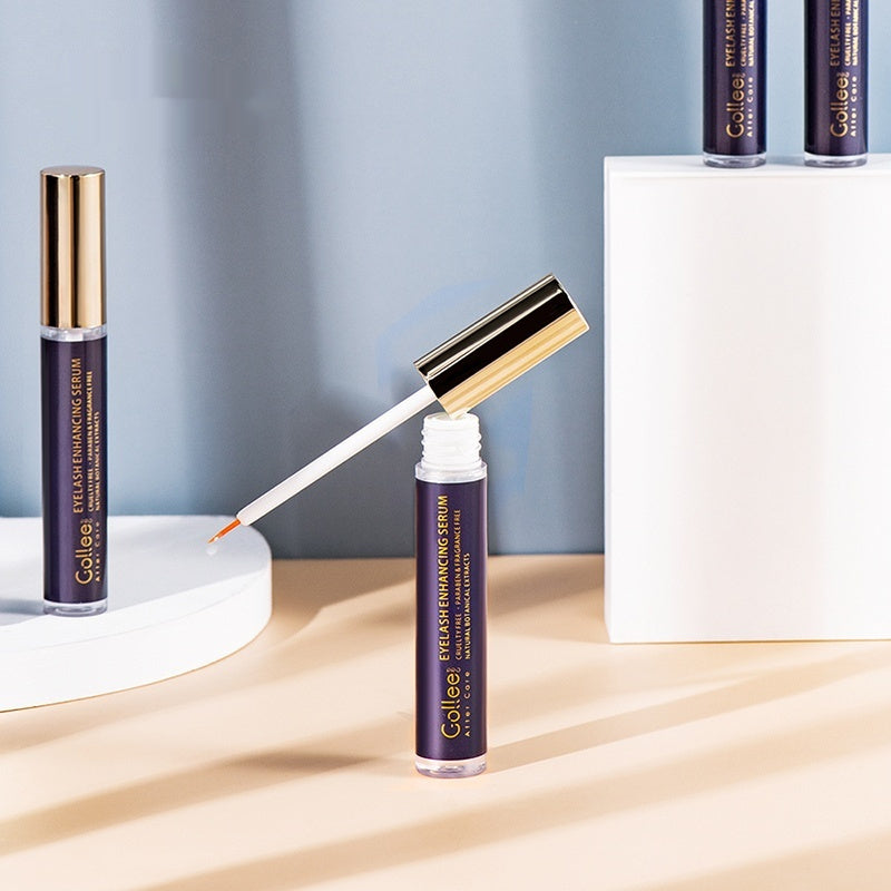 Eyelash serum with applicator on a light wooden surface and blue background