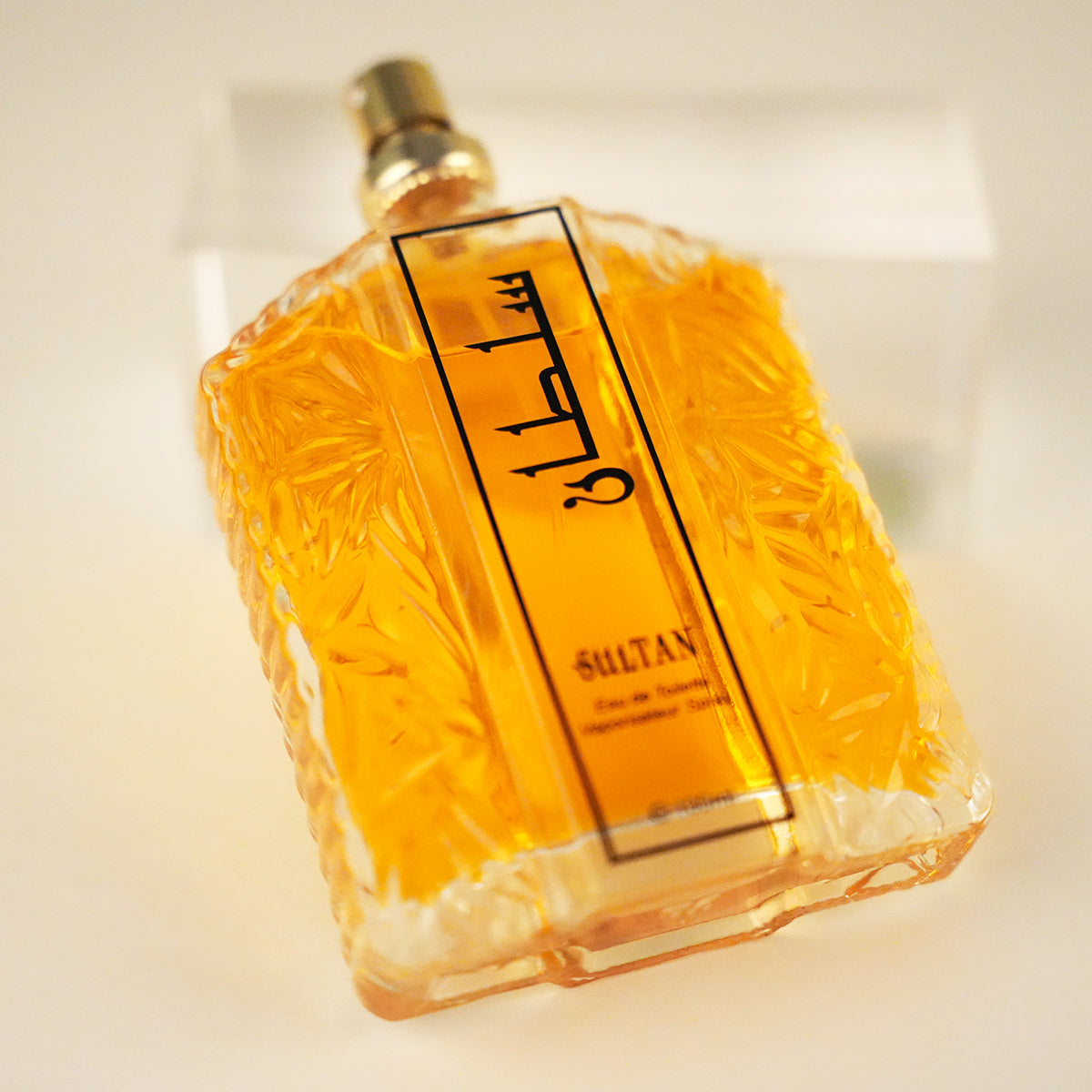 Perfume bottle with 'Sultan' branding on a light background