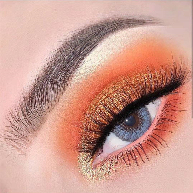 Close-up of a eye with orange and gold makeup