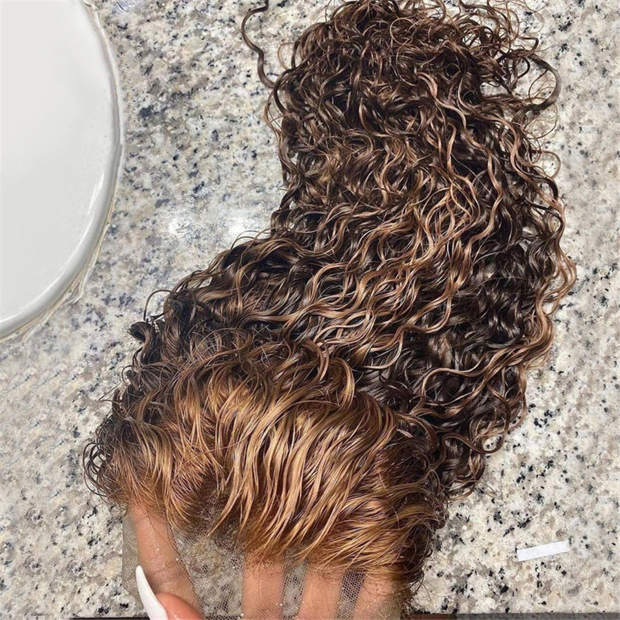 Curly hair strands on a marble surface with a white bowl.