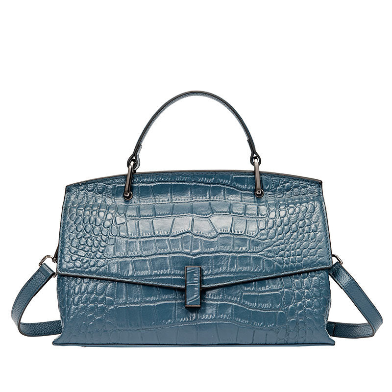 Blue textured handbag with a shoulder strap on a white background