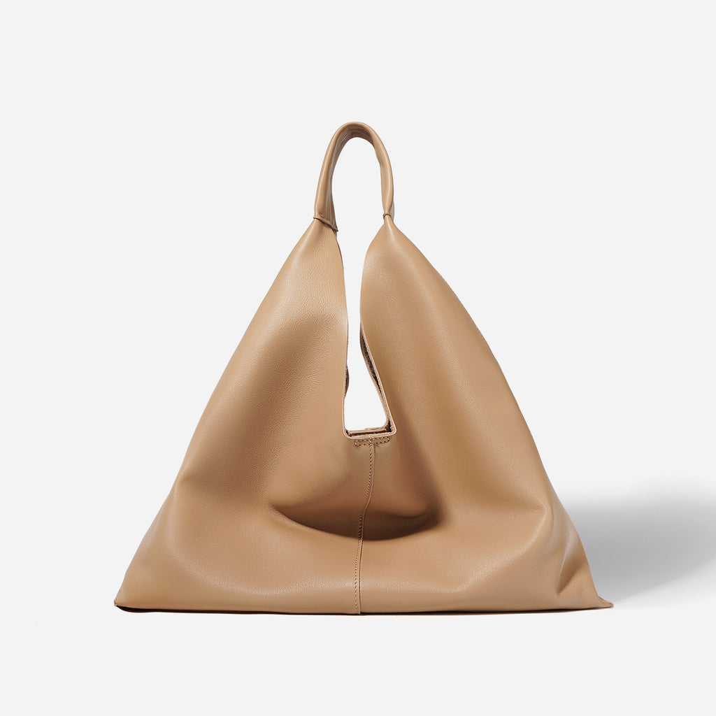 Tan leather handbag on a white background