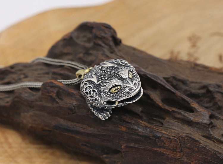 Silver panther pendant on a wooden surface