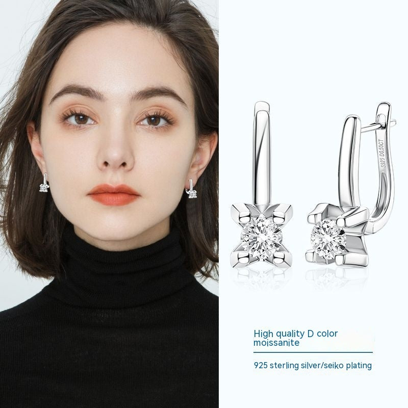 Woman wearing diamond earrings with close-up details on a white background