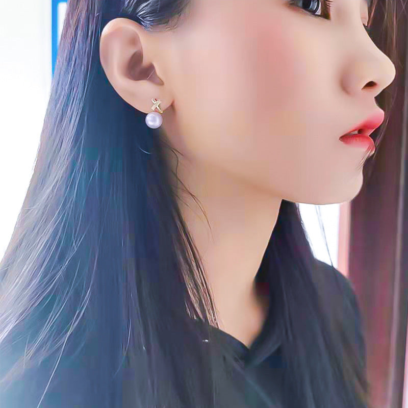 Close-up of a woman wearing a pearl earring with a blurred background