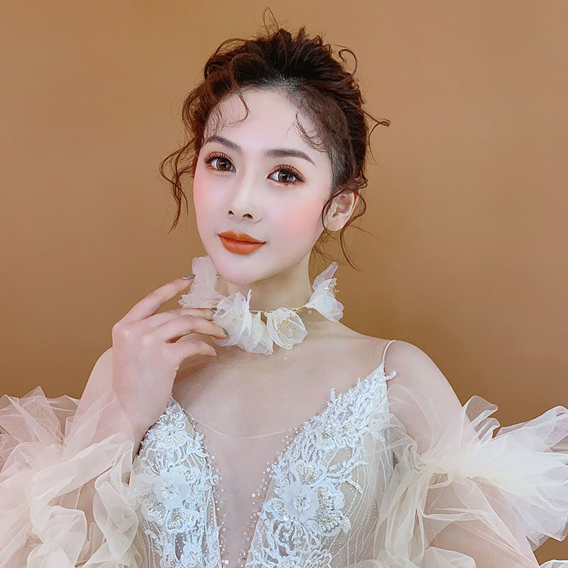 Woman wearing a white lace dress against a beige background