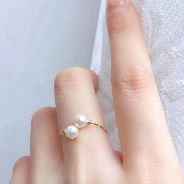 Pearl ring on a finger with a light background